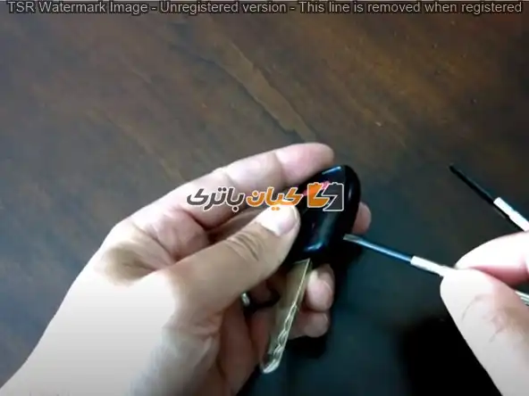 آموزش تعویض باتری ریموت خودروهای هوندا 27 یک پیچ گوشتی دو سو را در شکاف بین قسمت های بالا و پایین سوئیچ قرار دهید.