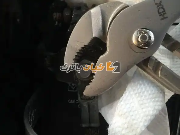 آموزش تعویض بست باتری ماشین 16 با استفاده از آچار، مهره را در خلاف جهت عقربه های ساعت بچرخانید و سپس آن را از پیچ جدا کنید.