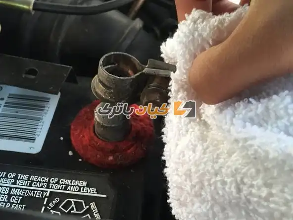 آموزش تعویض بست باتری ماشین 24 با استفاده از یک پارچه، ترمینال مثبت را دوباره روی گره مثبت قرار دهید.